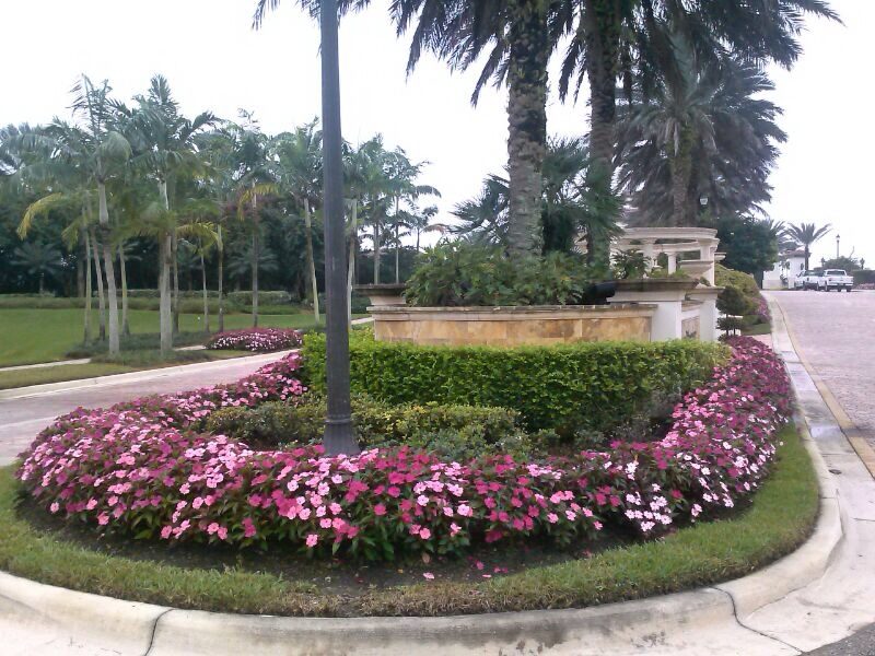 HOA community entrance with seasonal color beds and hedges